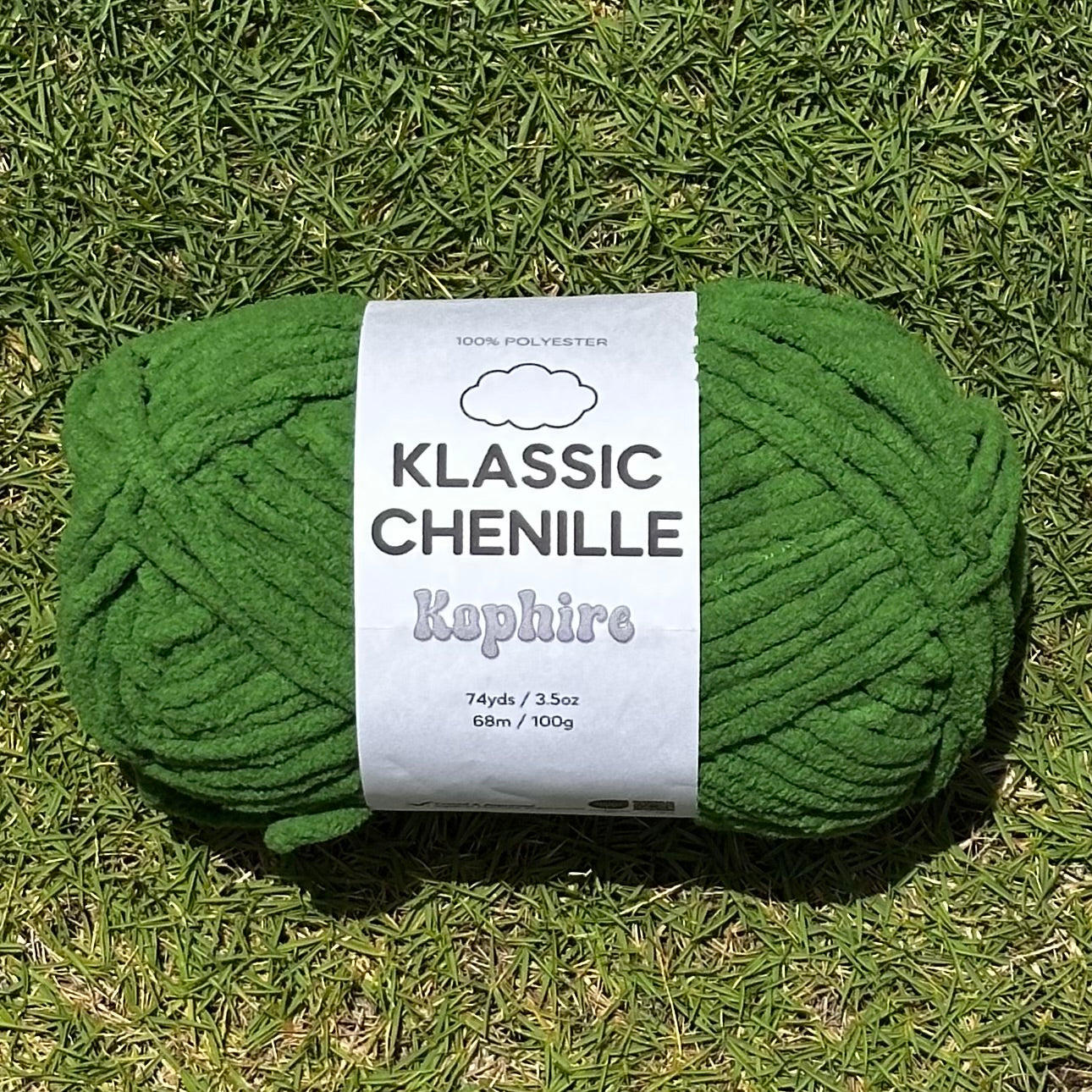 Green skein of yarn with a label on grass