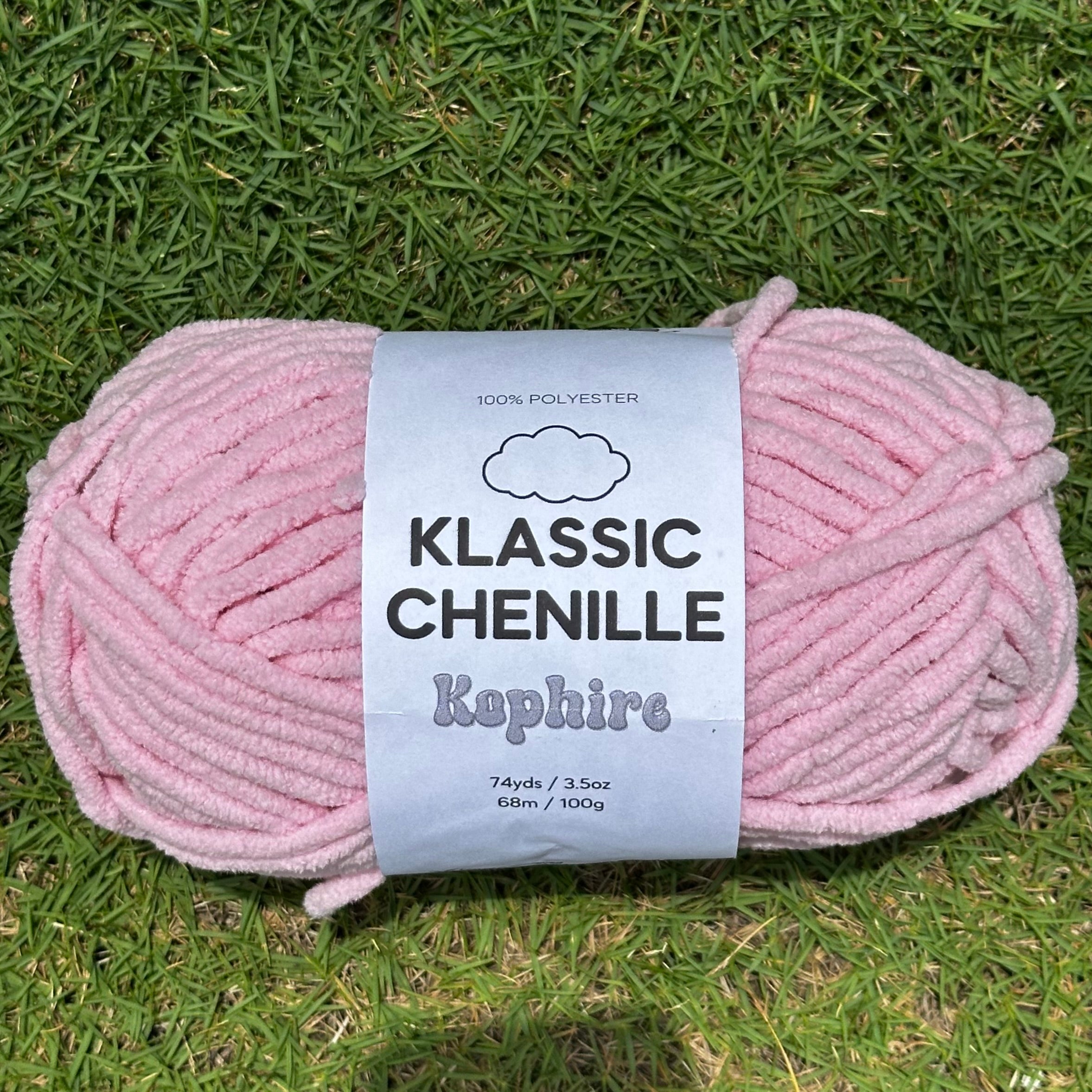 Light Pink skein of yarn with a label on grass