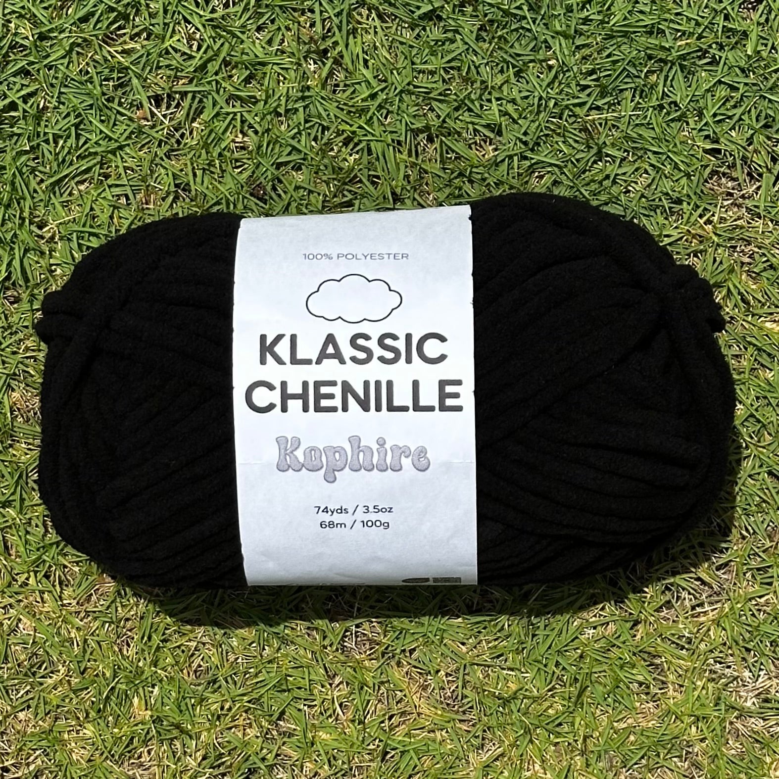 Black yarn ball with a label on grass