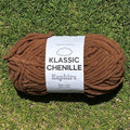 Brown ball of yarn with a label on grass