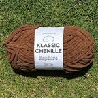 Brown ball of yarn with a label on grass