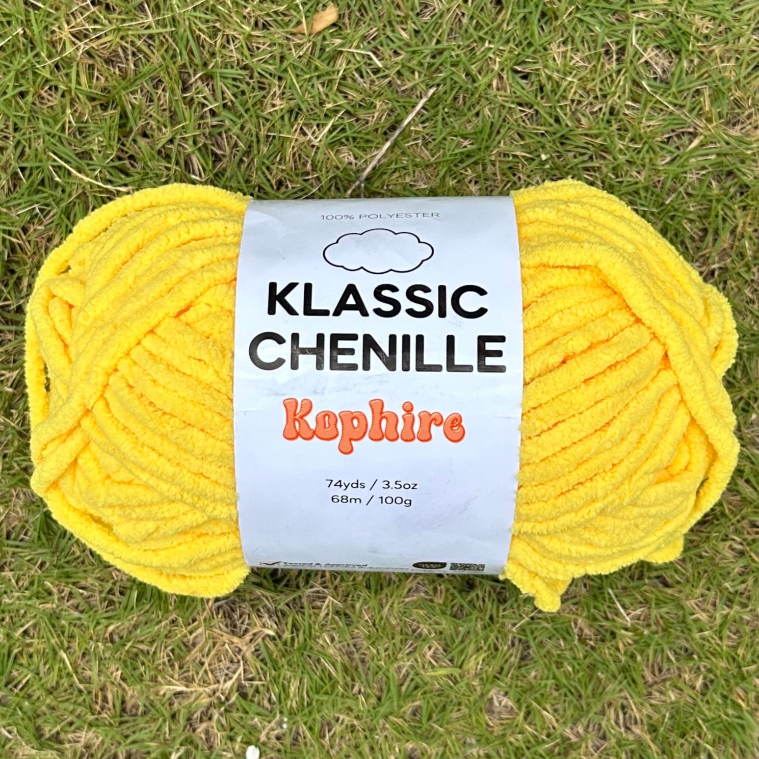 Yellow ball of yarn with a label on grass
