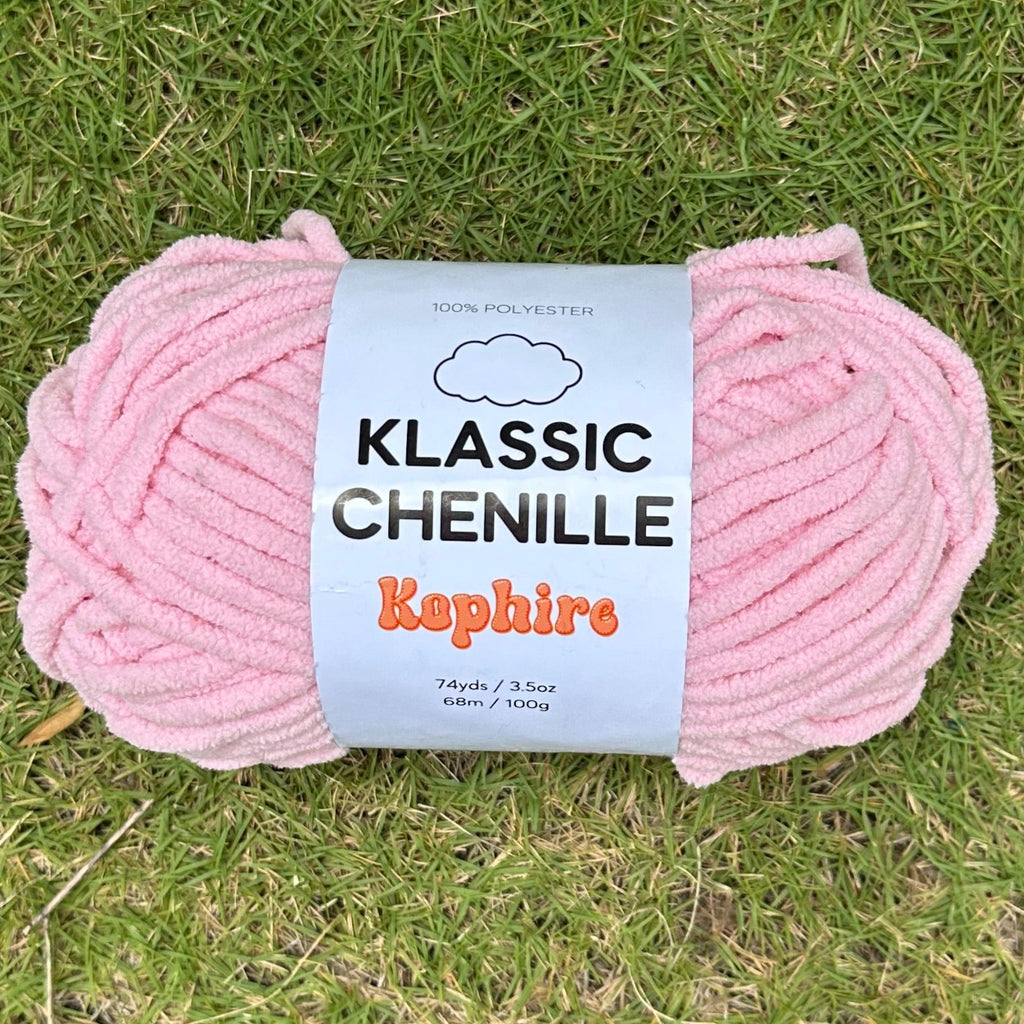 Pink skein of yarn with a label on grass
