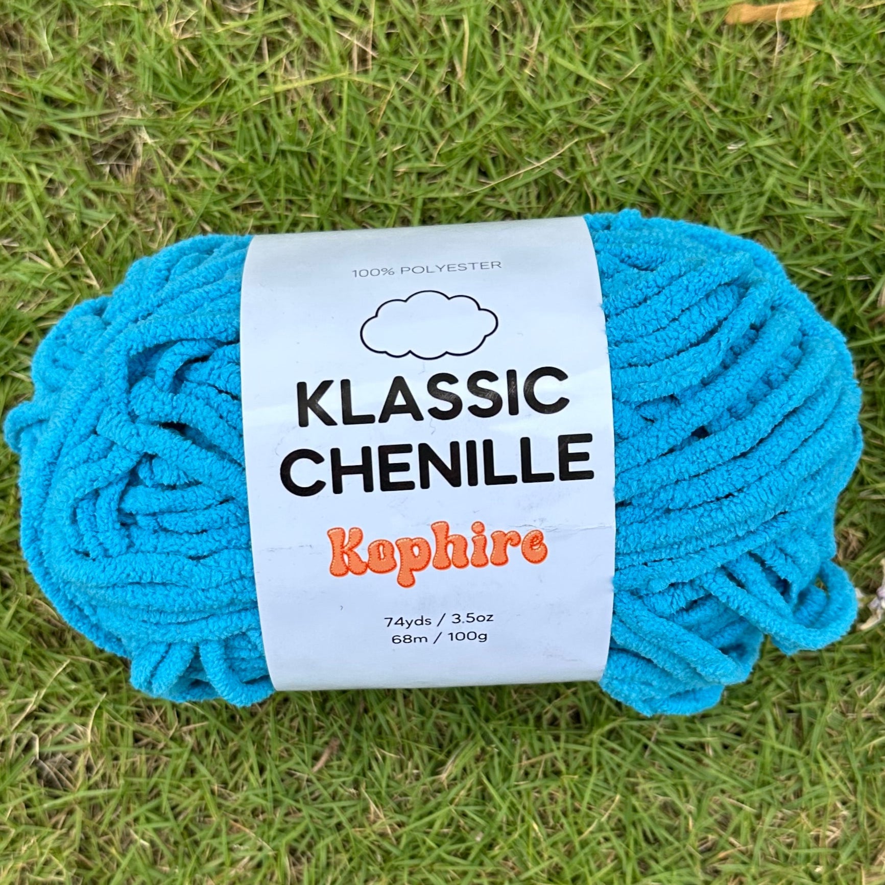 Blue skein of yarn with a label on grass