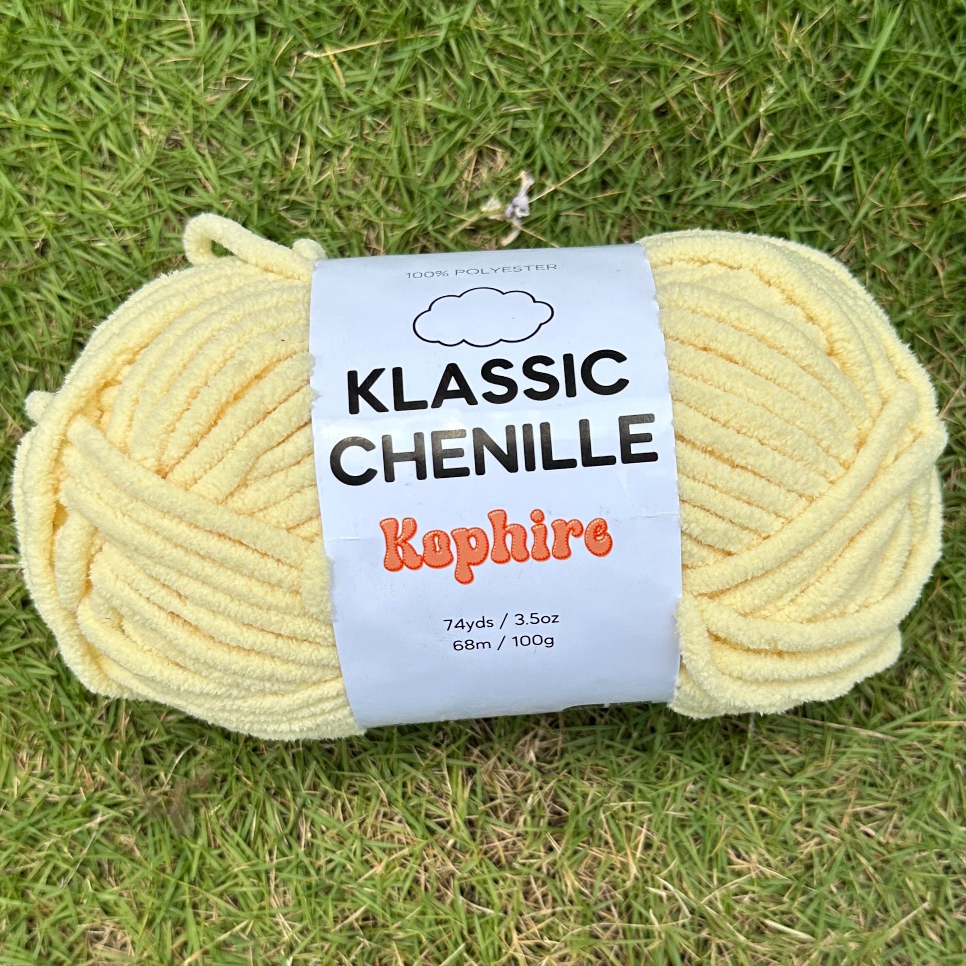 Ball of yellow yarn with a label on a grassy background