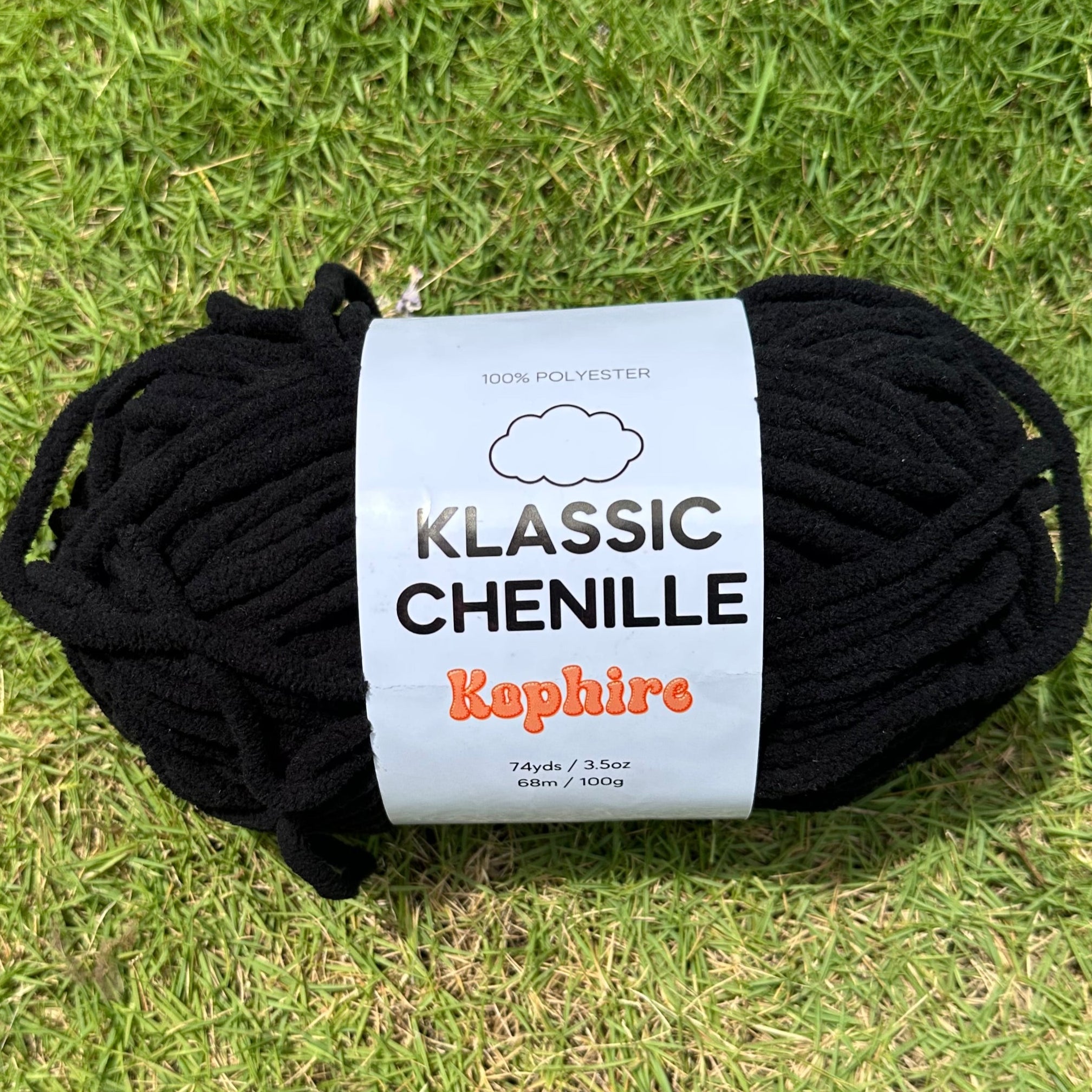 Black yarn ball with a label on grass